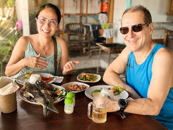 Guests enjoying grilled fish and local dishes at Divers Cafe restaurant in Amed